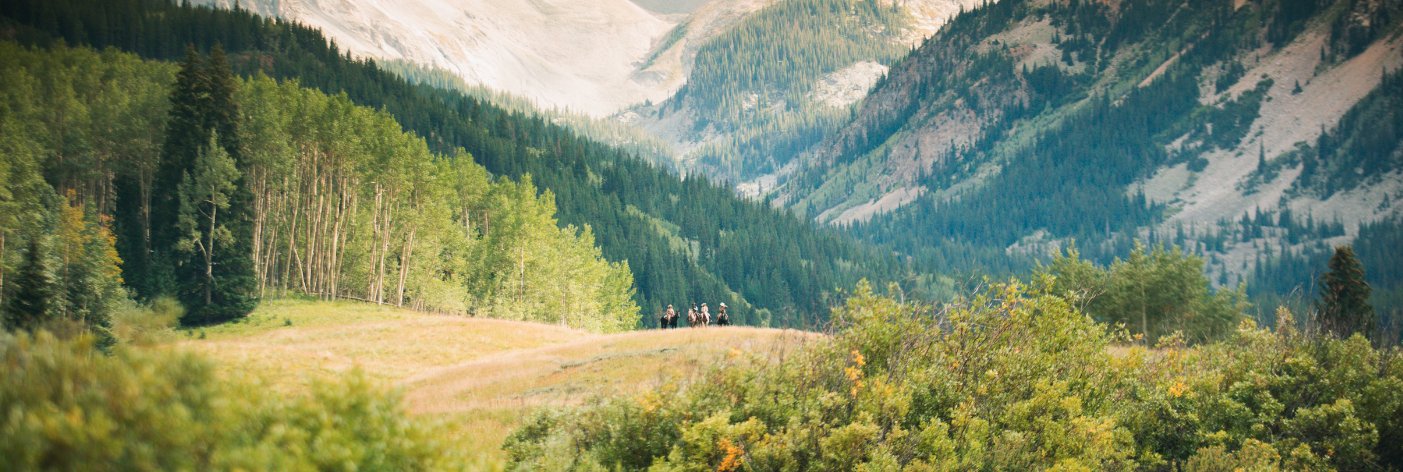Horseback riders in a mountain valley