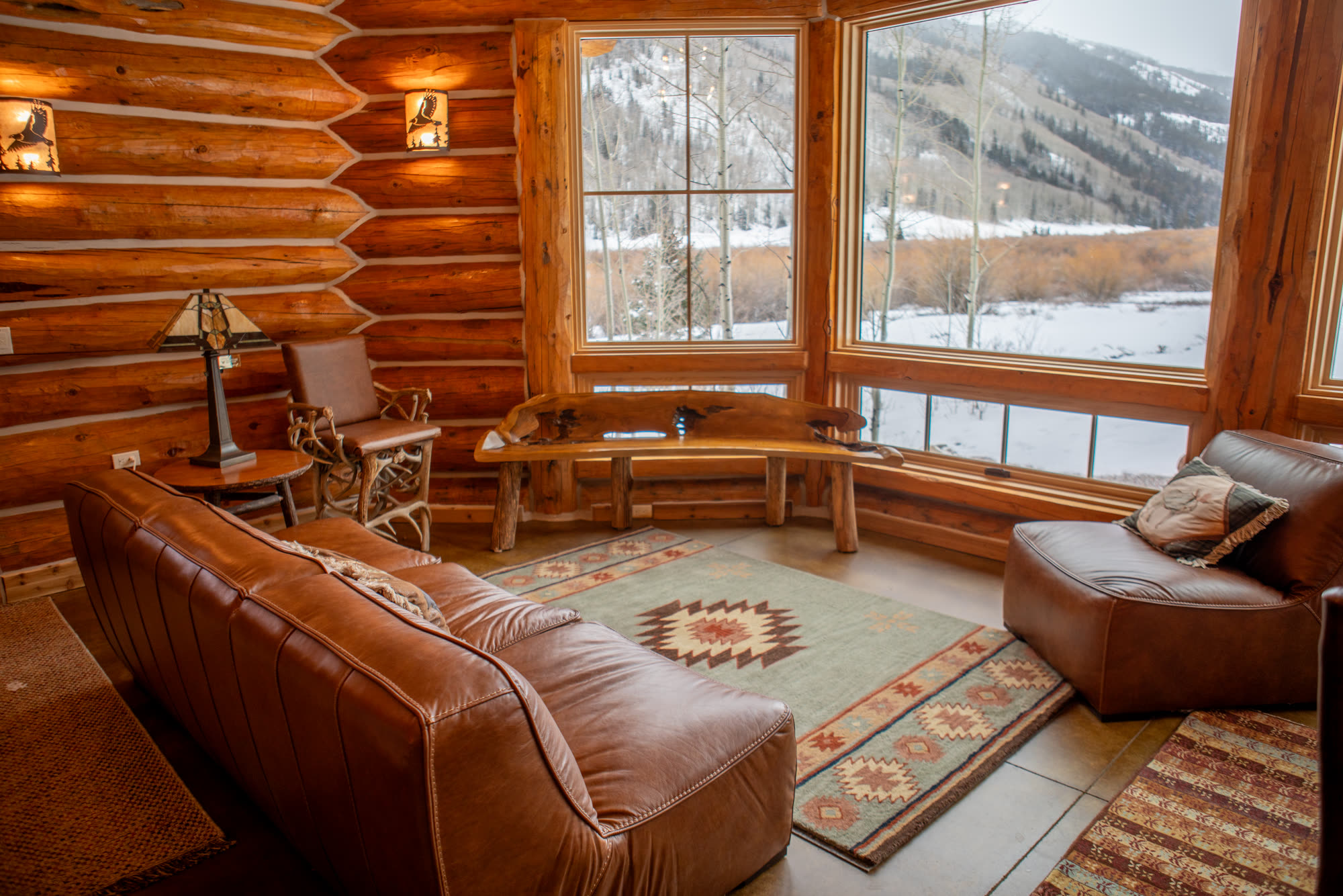 Cabin living room with leather sofa and mountain view